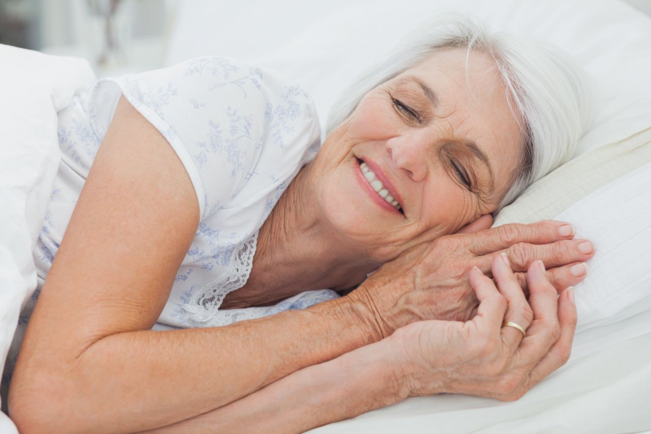 Femme souriant dans son lit